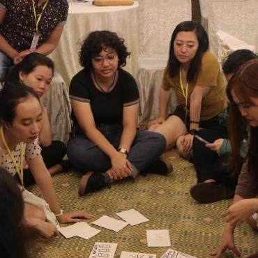 Image description: Women and girls sitting on floor 