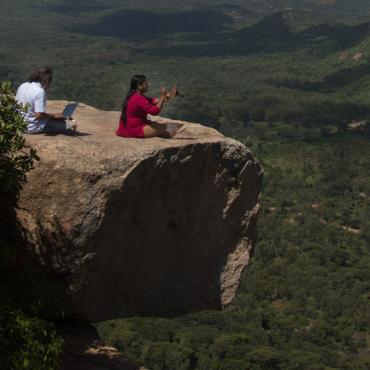 Image description: Two people check equipment on top of hill