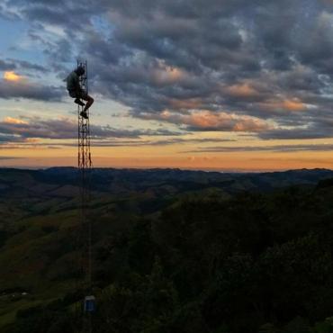 Image description: A lone body on tower against the sunrise and clouds