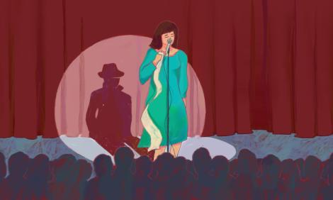 Woman on stage with a microphone and a piece of paper on her hand with her shadow as a stalker wearing a coat and a hat.