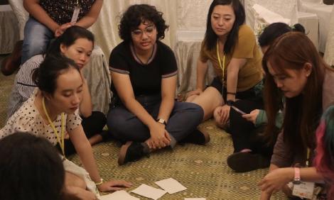 Image description: Women and girls sitting on floor 