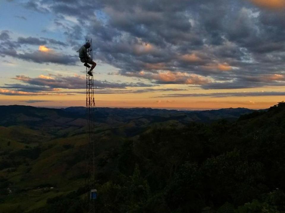 Image description: A lone body on tower against the sunrise and clouds