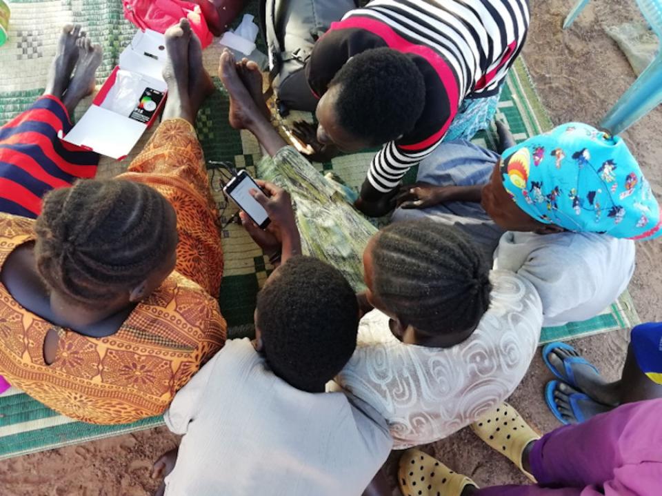 Image description: Overhead photo of a group of people with phone